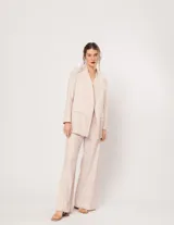 Pantalón negro de lino, tiro alto, corte palazo, con elástico en la pretina trasera, cierre delantero y broche interno. Tiene bolsillos laterales, dobladillo invisible y tajos a los costados.