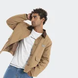 Campera estilo carpenter color beige con cuello de pana en contraste color marrón. Presenta cierre frontal con botones metálicos, bolsillos frontales con solapa y parche bordado con logo en el pecho. El interior cuenta con forro acolchado.