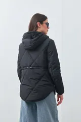 Campera matelasé color negro con capucha, cierre frontal con botones a presión y bolsillos frontales con cierre.
