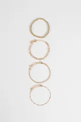 Set de cuatro pulseras de cadena en tono plateado con diferentes diseños, incluyendo una de esferas pequeñas, una de eslabones tipo figaro, una de cadena fina con pequeñas cuentas y una cadena delgada con detalles espaciados.