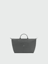 Bolso de viaje grande Longchamp modelo Le Pliage, color negro, confeccionado en nylon con detalles de cuero en las asas y solapa frontal con cierre de botón a presión.
