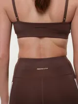 Top deportivo de breteles finos regulables, color rosado, con diseño liso y escote redondo.