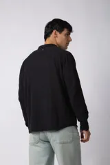 Camisa de manga larga confeccionada en tejido de lino con textura, de corte holgado y diseño versátil con cierre frontal de botones.