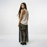 Falda midi de tul negro con diseño geométrico y arabescos bordados en hilo negro y lentejuelas. Presenta una silueta recta con transparencia y forro corto integrado.