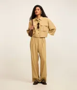 Pantalón recto de tiro alto color beige, confeccionado en viscosa, de diseño clásico y fluido con cierre frontal y bolsillos.