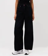 Pantalón de jean con corte barrel, de tiro medio y piernas anchas. Presenta un lavado marmorizado, trabillas en la cintura, cierre frontal con botón y cremallera, bolsillos funcionales y recortes decorativos en las rodillas.