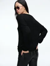 Cardigan de punto con hilo brillante, cuello en V y cierre frontal con botones. Presenta mangas largas con puños acanalados y un diseño de calce holgado.