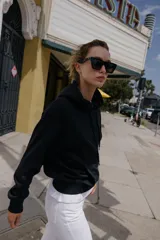 Sudadera de manga larga con capucha ajustable mediante cordones, bolsillo frontal tipo canguro y puños y ruedo en tejido rib.