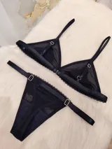 Conjunto de lencería compuesto por un corpiño triangular de microtul transparente con detalles de encaje en las copas y una tanga regulable de elástico ancho.