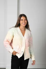 Saco tipo cardigan de punto con textura de panal, en tonos pastel multicolor. Presenta escote en V, cierre frontal con botones, mangas largas con puños acanalados y bolsillos delanteros.
