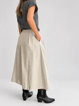 Pantalón palazzo color beige, de tiro alto y calce amplio, con pinzas frontales y bolsillos laterales.