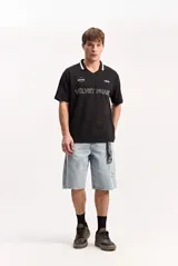 Remera polo beige con textura, cuello en V con solapa y detalles en contraste, de manga corta y diseño urbano con estampas frontales.