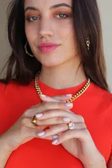 Anillo dorado macizo con cristal claro cuadrado en el frente.