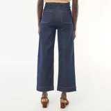 Pantalón de jean azul oscuro de corte recto y largo cropped, con diseño de tiro alto, bolsillos frontales tipo parche y cierre de botones metálicos.