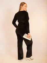 Pantalón de terciopelo negro con pequeños puntos brillantes plateados, corte recto y tiro medio.