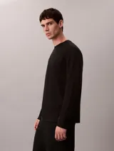 Remera de manga larga Calvin Klein confeccionada en algodón con tejido interlock. Presenta cuello redondo, corte regular y un sutil logo de la marca bordado en el pecho.