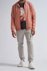 Chaqueta deportiva con cierre frontal, capucha ajustable con cordones y puños elásticos, en color rosa.