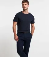 Pantalón de vestir para hombre, color beige claro, de corte slim y sastrería. Presenta cierre frontal con botón y cremallera, y bolsillos laterales y traseros.