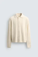 Cárdigan de ajuste relajado, tejido en hilado con lana, color crema. Presenta cuello solapa, manga larga y textura de punto trenzado en todo el cuerpo. Cierre frontal con botones.