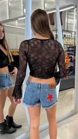 Short de jean azul con lavado clásico, corte de tiro bajo y ruedo deshilachado. Presenta un parche de estrella roja en uno de los bolsillos traseros y etiqueta de cuero con logo en la cintura.