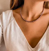 Gargantilla de cuentas violetas con detalles dorados y cadena de ajuste.