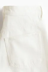 Bermuda de cinco bolsillos en denim de algodón rígido, color blanco, de tiro alto con cierre y botón.