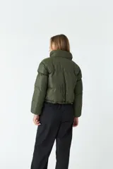 Campera puffer corta color ladrillo, con cuello alto y cierre frontal.