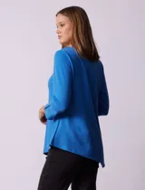 Blusa verde manzana en tejido acanalado, marca Ruby Rd. Largo de mangas ¾ con abertura y botones. Terminación de ruedo asimétrico.