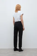Pantalón chino de corte recto y tiro medio, color negro, con bolsillos laterales y cierre frontal con botón y cremallera.