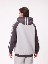 Canguro con capucha de estilo deportivo, con cuerpo en color celeste y mangas raglán en color negro. Presenta el logo de la marca estampado en el pecho, bolsillo tipo canguro frontal y franjas blancas laterales en las mangas.