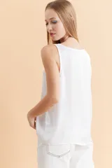 Musculosa de satén con escote redondo, corte holgado y diseño minimalista.