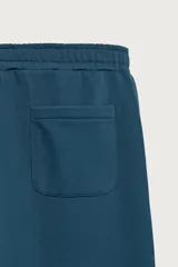 Pantalón jogger de corte relajado y pernera ancha, confeccionado en tejido de algodón con interior perchado. Cuenta con cintura elástica ajustable mediante cordón interior, bolsillos laterales y un bolsillo trasero de plastrón.