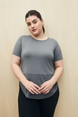 Remera deportiva color lila de manga corta con calce relajado y corte horizontal en la parte inferior.