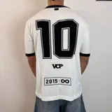 Remera de tejido de punto color blanco con detalles en negro en cuello y mangas. Presenta un diseño estampado en la espalda que incluye el número 10, las siglas VCP y un recuadro con la inscripción 2015-infinito.