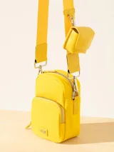 Bandolera amarilla con correa fina regulable y monedero colgante.