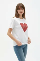 Remera de algodón blanca, de corte holgado, con cuello redondo y diseño estampado en el centro que incluye un gato comiendo de un plato y la inscripción 'Wild Cats'.