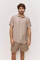 Camisa de manga corta con diseño a rayas verticales en tonos tostado, blanco y azul. Cuenta con cuello clásico y cierre frontal de botones.