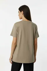 Remera de algodón manga corta con cuello redondo y corte al cuerpo. Presenta un estampado central con diseño artístico y detalles de studs aplicados.