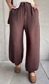 Pantalón de corte babucha color chocolate, de diseño holgado con cintura elástica fruncida y cordón ajustable.