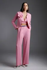 Pantalón de vestir rosa de corte palazzo, con cintura alta y cinturón fino azul con hebilla plateada.