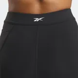 Calza deportiva de tiro alto color negro con detalles curvos en color turquesa y paneles de malla en los laterales. Confeccionada en tejido elástico de alta compresión.