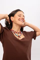 Collar corto elaborado con cuentas de turquesa reconstituida, piezas de nácar blanco, cuentas de cristal rojo y turquesa, y un dije central con forma de rama de coral.