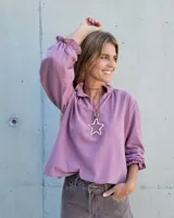 Blusa de algodón con cuello mao y volados, mangas largas con puños elásticos y corte holgado.