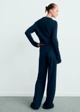 Pantalón de punto de corte recto y tiro alto, con cintura elástica y diseño fluido. Presenta una caída amplia y cómoda, ideal para un look sofisticado y relajado.