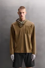 Camiseta de algodón de corte relajado (relaxed fit), color verde oliva, con cuello redondo, manga larga y bolsillo plastrón con cierre de cremallera en el pecho.