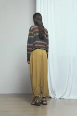 Pantalón barrel de lino color verde, de tiro medio con cintura elástica ajustable mediante cordón y bolsillos laterales.