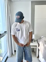 Remera blanca de manga corta con estampado gráfico en azul en la espalda, que incluye el texto "BROKERS GRAPHIC RESEARCHING" y varios logos de la marca.