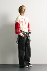 Camiseta boxy fit de cuello redondo y manga por debajo del codo. Presenta un diseño bicolor en tonos blanco off-white y rojo, con estampado y parches frontales con efecto lavado vintage y franjas en las mangas.