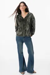 Camisa de manga larga confeccionada en terciopelo con acabado arrugado. Presenta cuello clásico, cierre frontal con botones y puños abotonados.