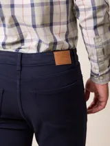 Jean de corte recto y tiro medio en color azul marino, con cierre de botón y cremallera, y bolsillos laterales y traseros.